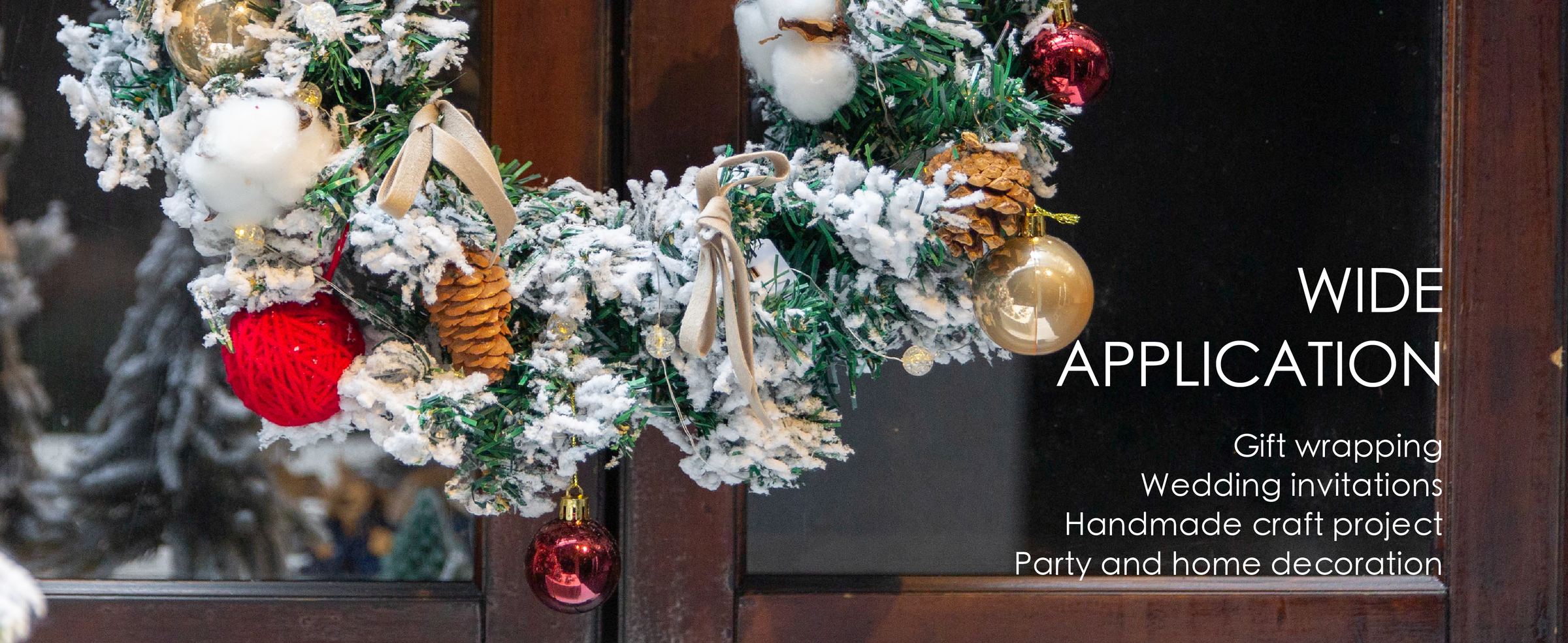Camel velvet ribbon bows decorate a snowy evergreen wreath with pinecones, lights, and ornaments.