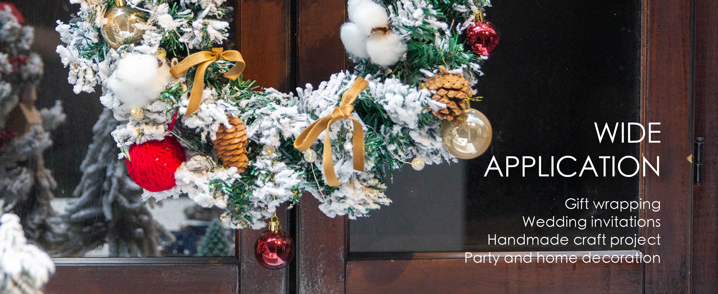 Khaki velvet ribbon bows decorate a snowy holiday wreath with pinecones, lights, and ornaments.