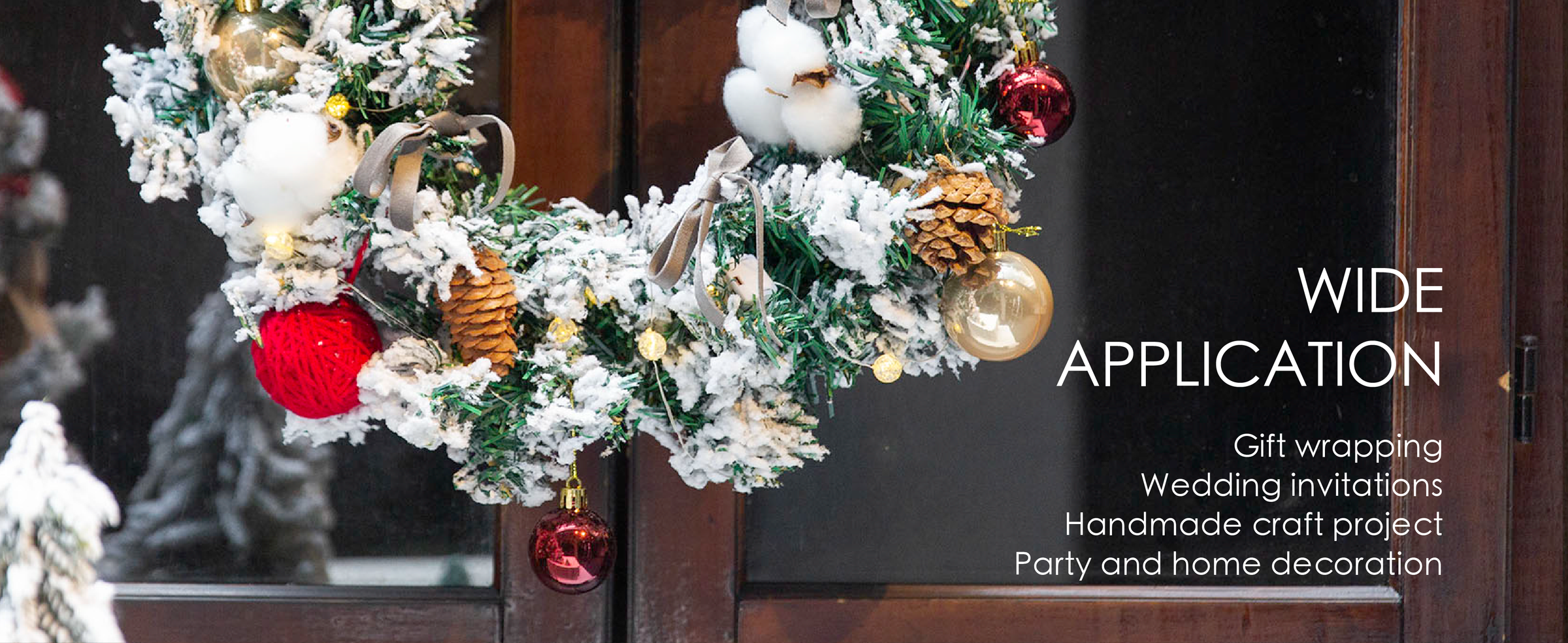 Gray velvet ribbon bows decorate a snowy Christmas wreath with pinecones and ornaments.