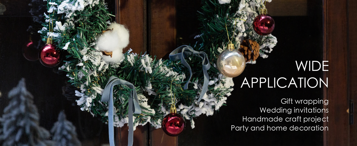 Dusty blue velvet ribbon bows decorate a snowy Christmas wreath with pinecones and ornaments.