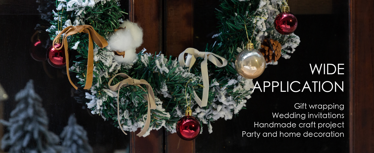 Ivory, tan, and gray-nude velvet ribbon bows decorate a snowy Christmas wreath with baubles.