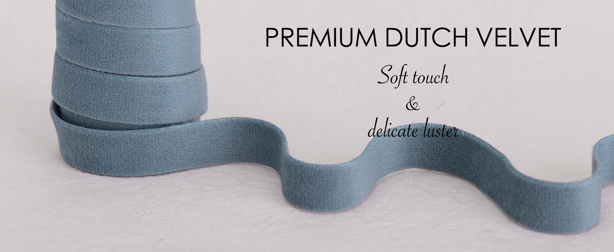 Close-up of dusty blue, ivory, and dusty green velvet ribbon showing its short, plush texture.