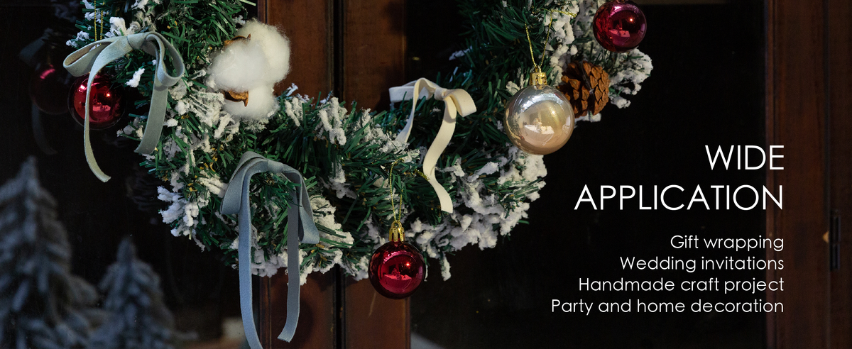 Dusty blue, ivory, and pale green velvet ribbon bows decorate a snowy Christmas wreath.