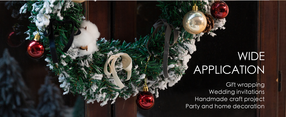 Ivory, black, and gray velvet ribbon bows decorate a snowy Christmas wreath with red and gold ornaments.