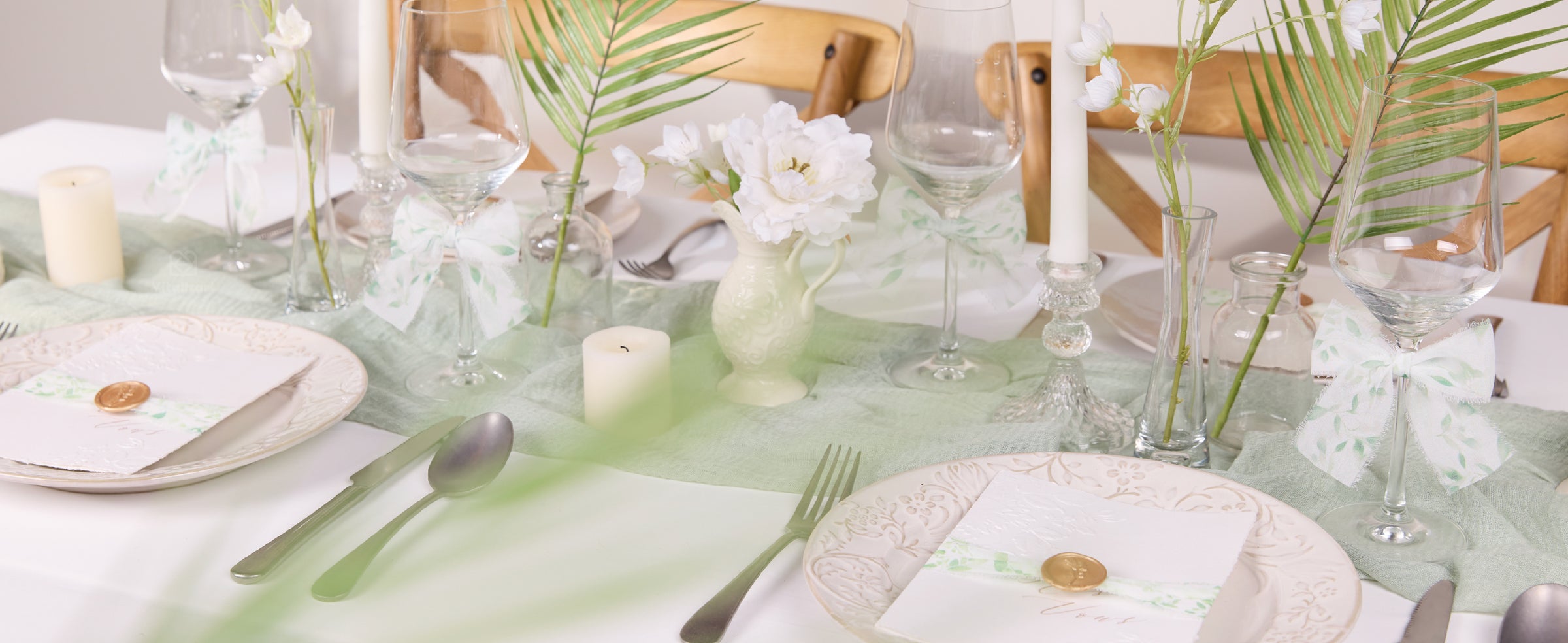 Roll of translucent white frayed ribbon with a soft green leafy branch print