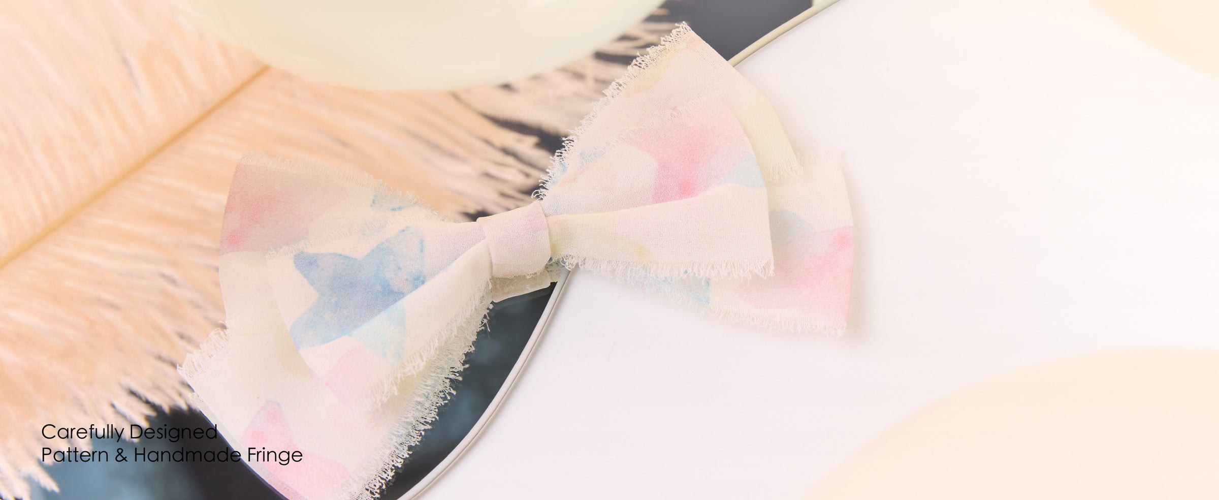 Pastel blue and pink printed chiffon ribbon tied in a layered bow with soft handmade fringe