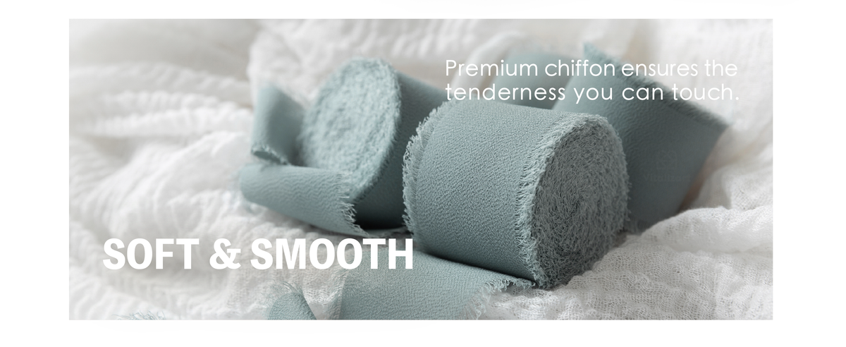 Dusty blue chiffon ribbon rolls with soft woven texture and feathery frayed edges resting on white gauze.