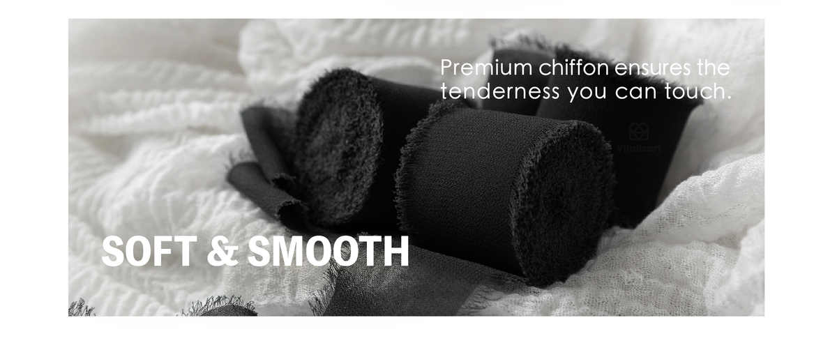 Black chiffon ribbon rolls with smooth woven surfaces and soft, visibly fringed edges on white fabric.