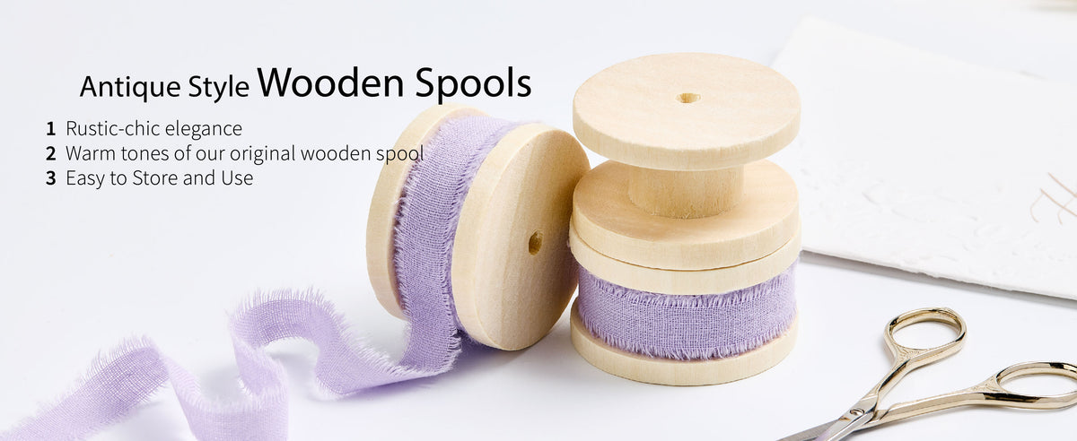 Lavender frayed cotton ribbon on pale wooden spools beside gold scissors and a loose ribbon trail