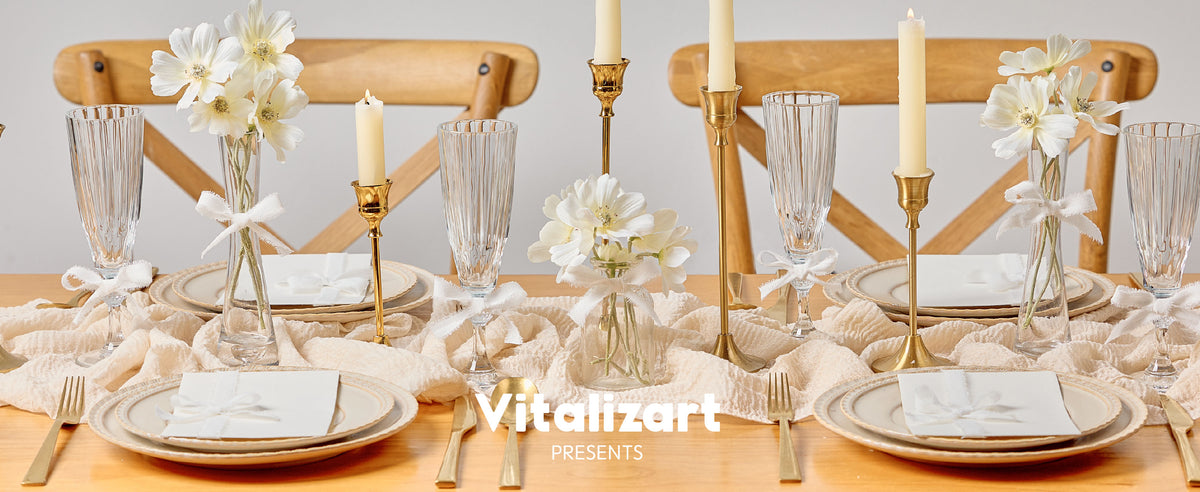 White frayed ribbon bows decorate flower vases and glassware on an elegant candlelit dining table