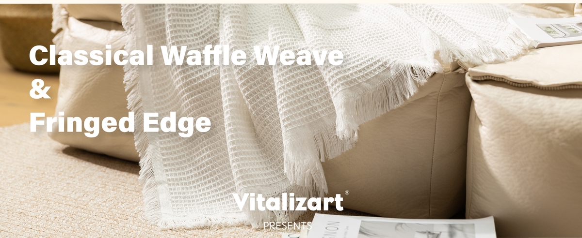 Close-up of a white waffle-weave throw with textured squares and long fringed edges