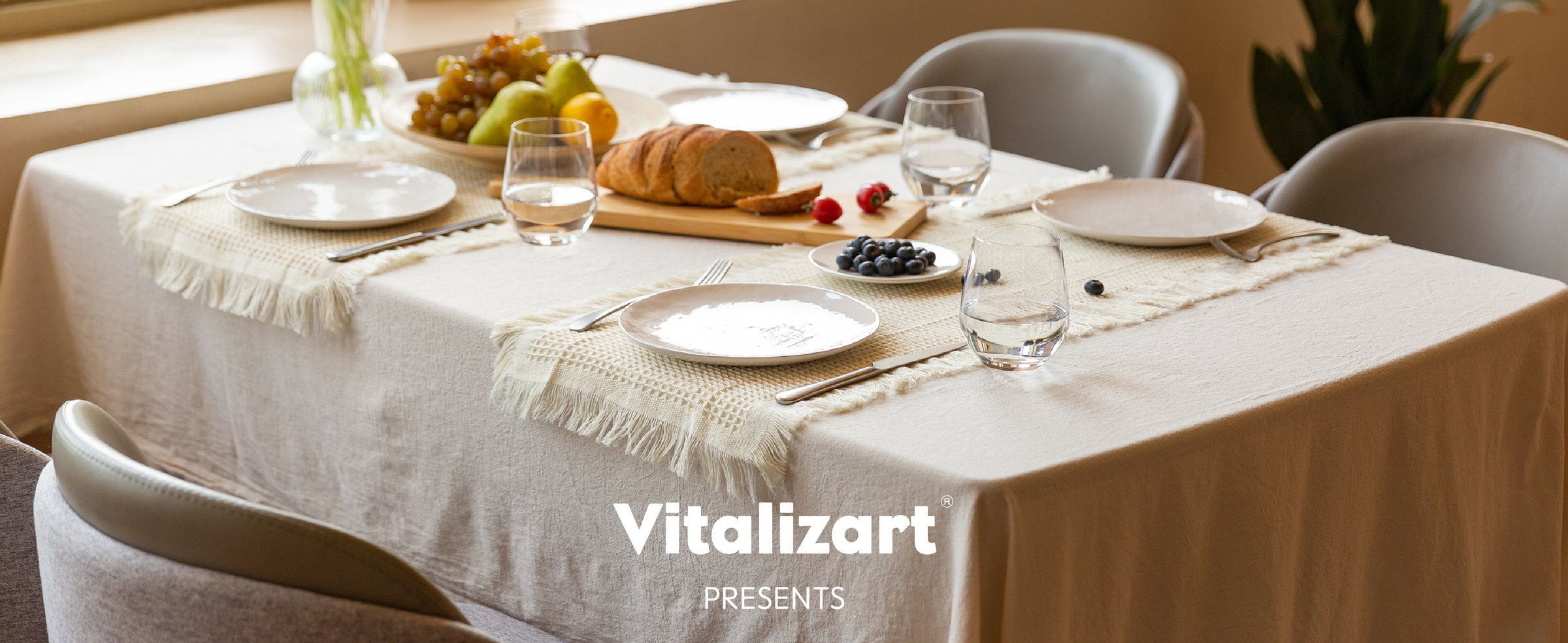 Cream waffle-weave table runners set with plates, fruit, bread, glasses, and pink tulips