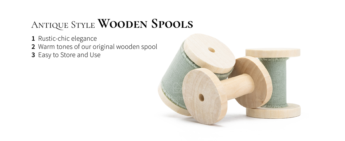 Dusty green fringed cotton ribbon wound on pale wooden spools, with one empty spool in front.