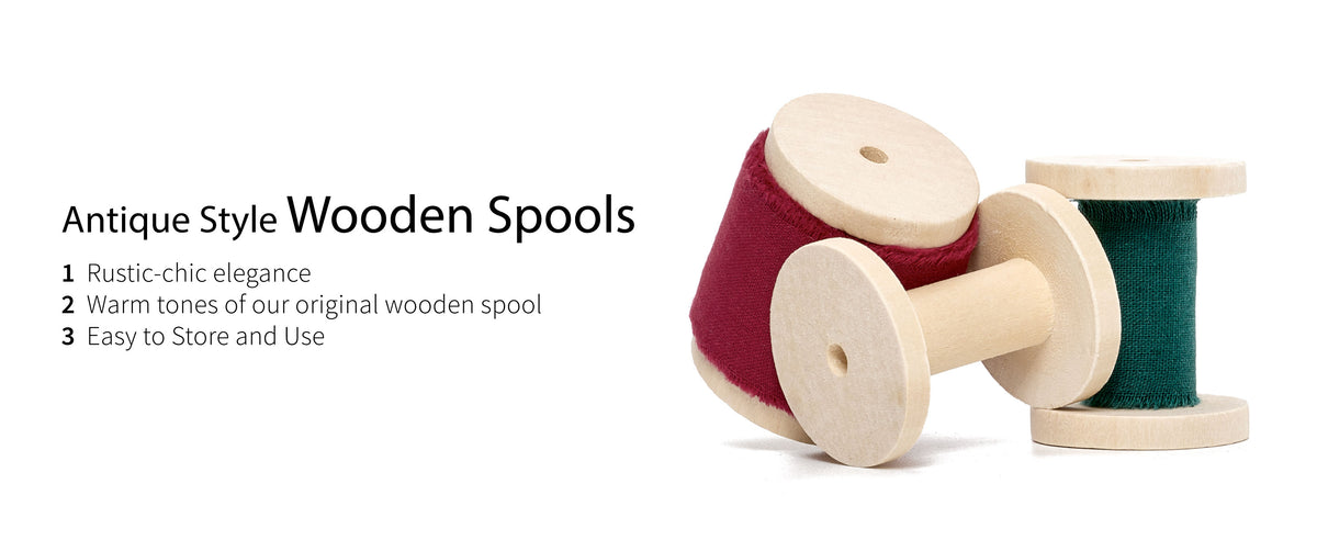 Red and green frayed cotton ribbons displayed on pale wooden spools with natural grain and center holes.