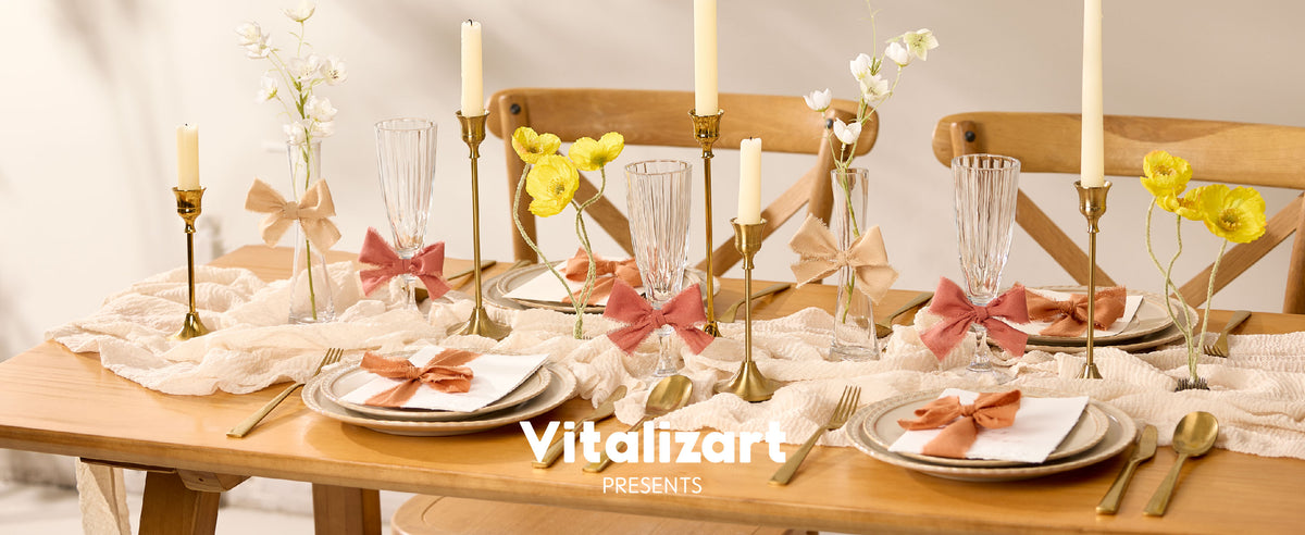 Terracotta and beige fringed ribbon bows decorate glasses, napkins, and vases on a set dining table
