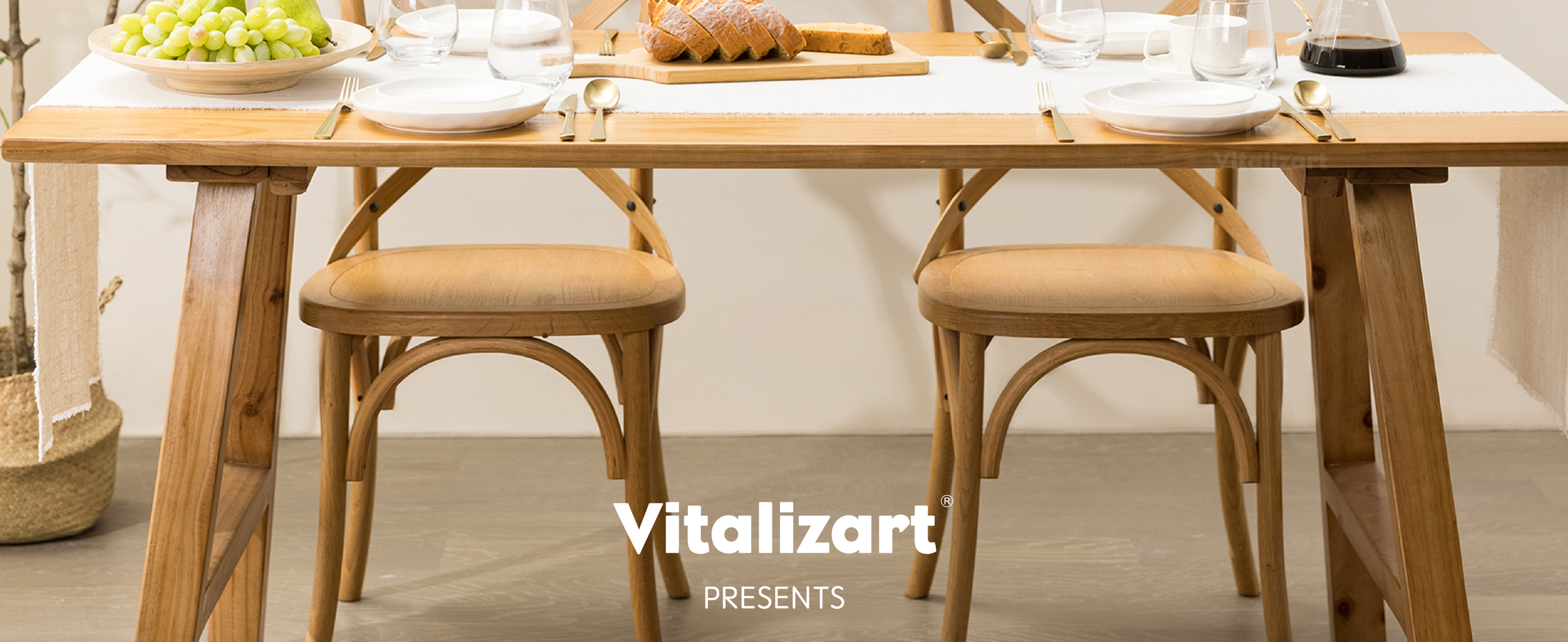 Long light beige fringed table runner on a dining table set for two with bread, fruit, and glassware.