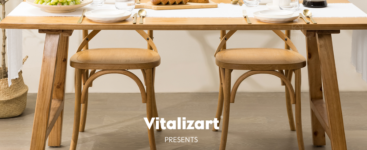 White fringed table runner on a wooden dining table set for two with bread and grapes