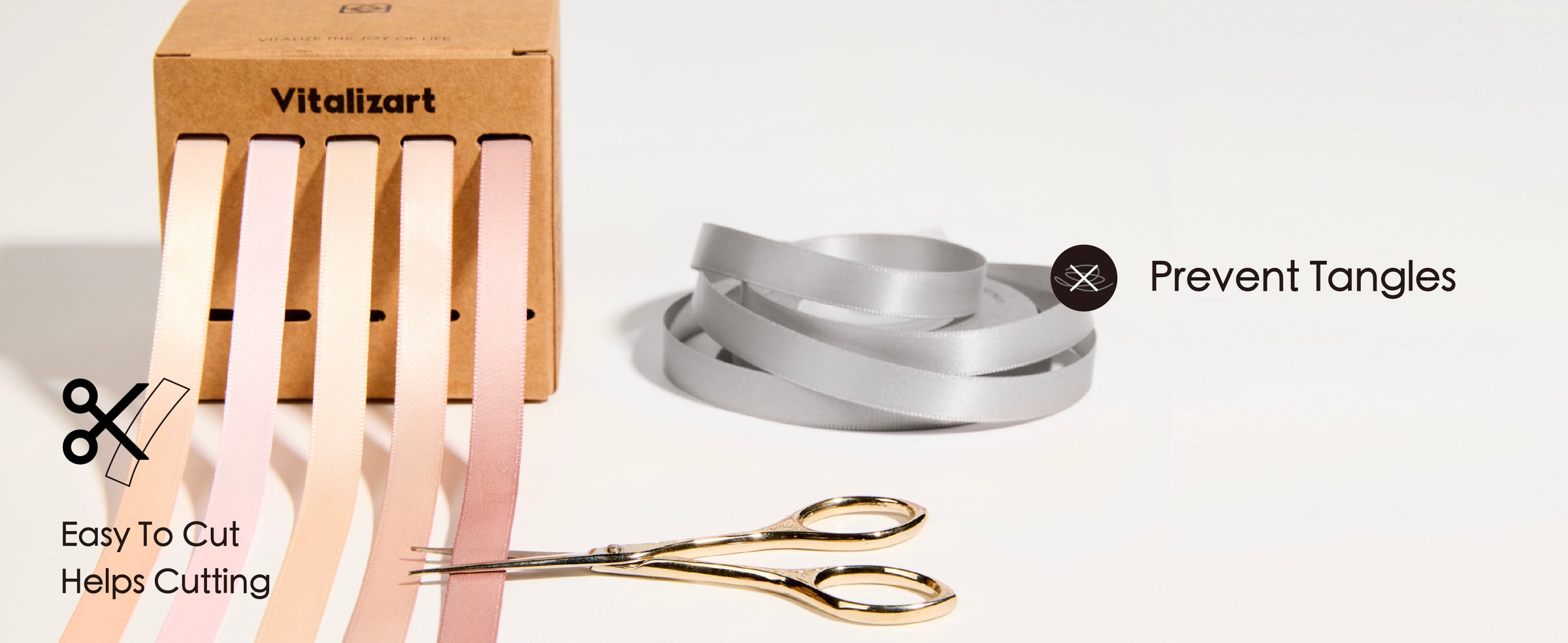 Five pale satin ribbons feed separately from a kraft dispenser beside a loose ribbon coil and gold scissors.