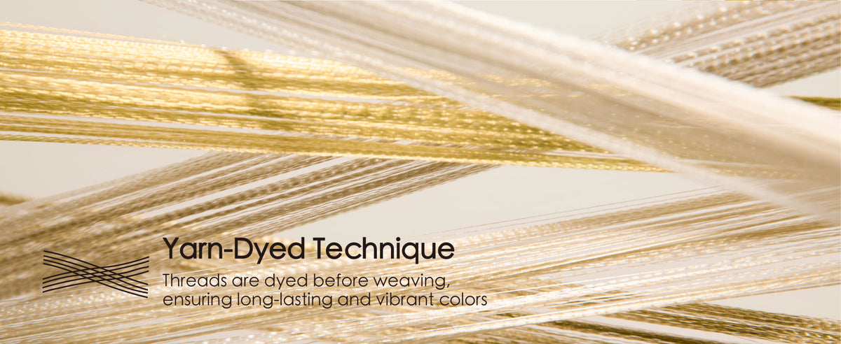 Close-up of crossing cream, champagne, and gold ribbon threads illustrating yarn-dyed construction
