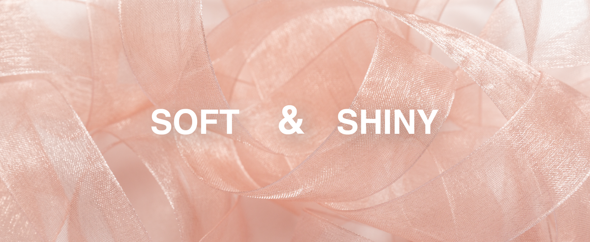 Rose-pink sheer organza ribbon in loose overlapping loops, showing its fine weave and subtle shine.