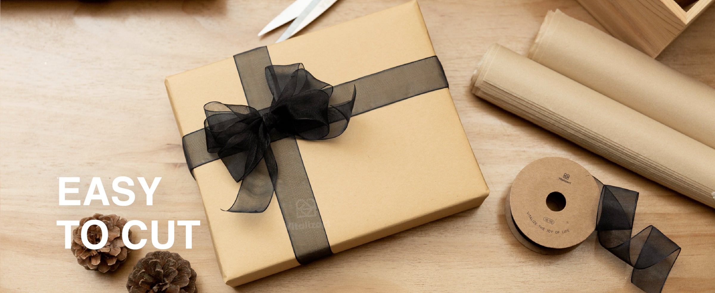 Black organza ribbon accents place cards on a candlelit Christmas table with evergreen garland.