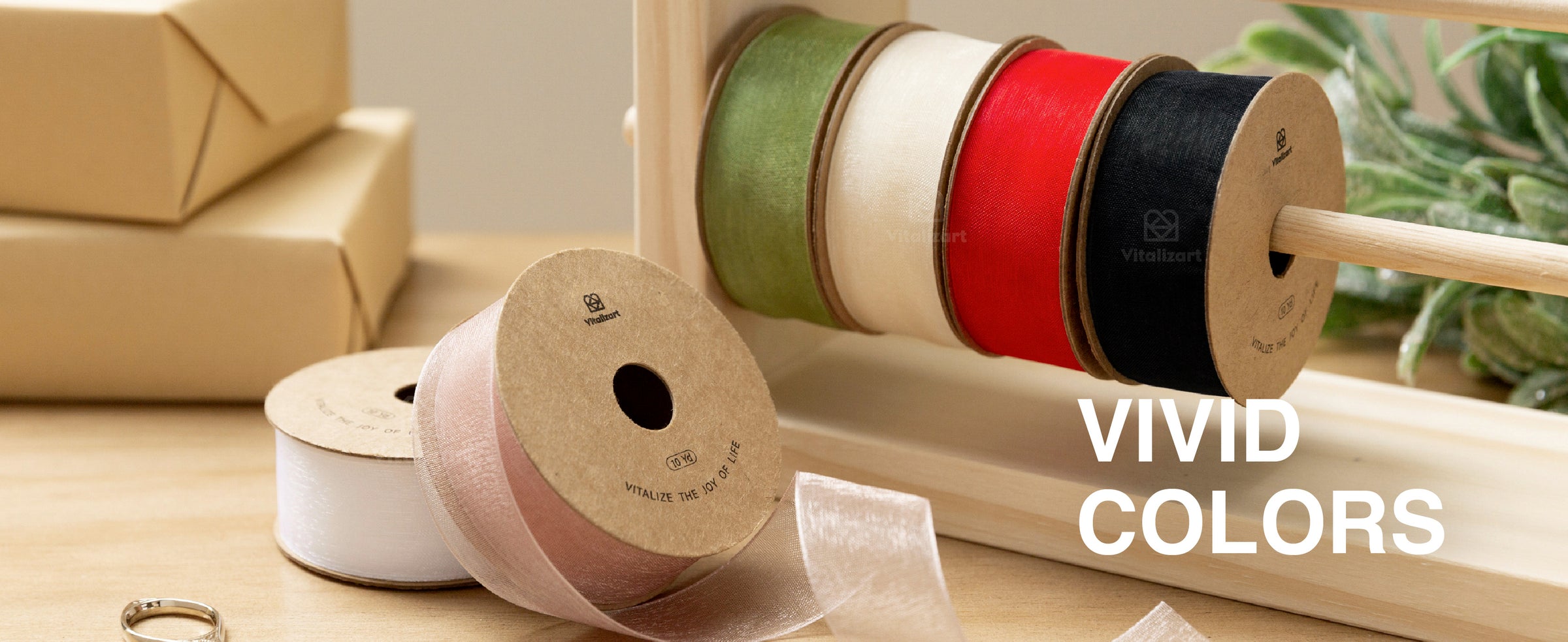 Black sheer organza ribbon and bows decorate stacked kraft and white gifts by a Christmas tree.
