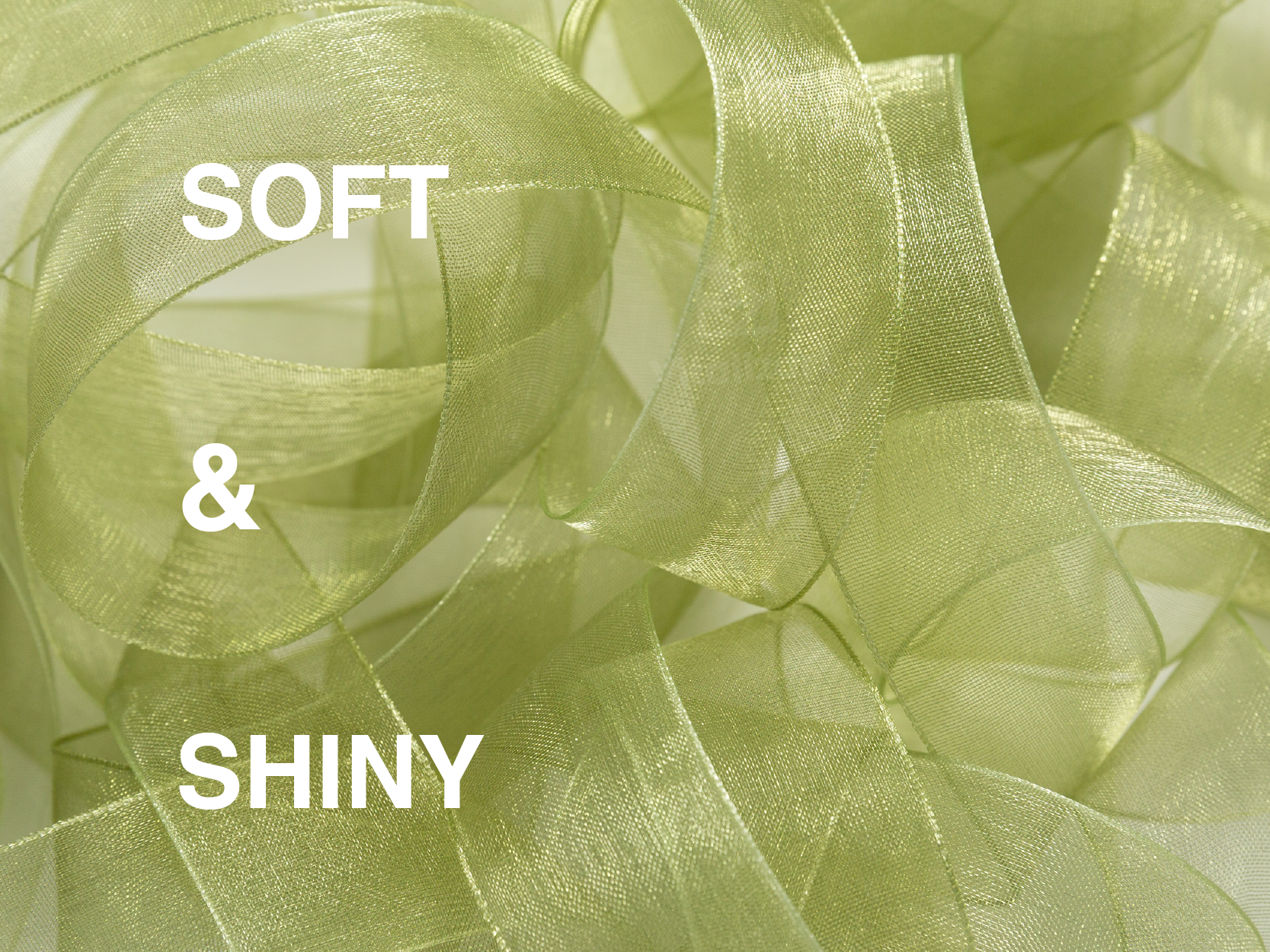 Close-up of soft, shiny pale green organza ribbon arranged in translucent loops