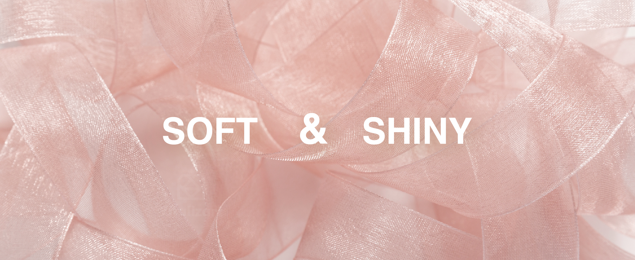 Close-up of soft, shiny rose-gold organza ribbon arranged in loose translucent loops.