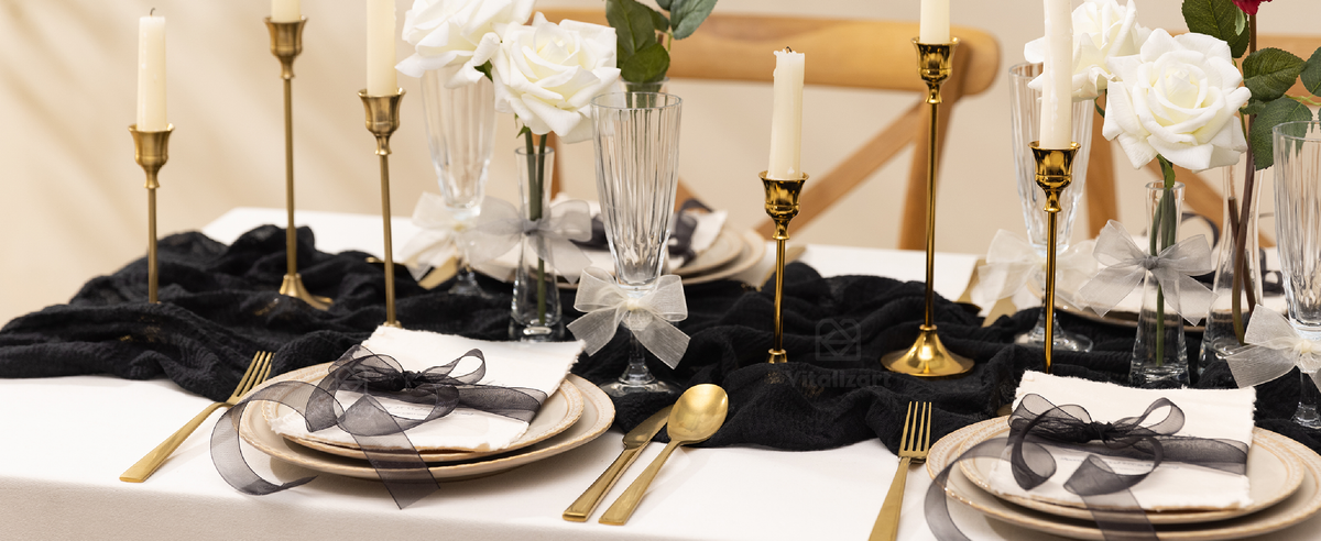 Black and silver-white organza bows decorate plates, glasses, and vases on a formal dining table.