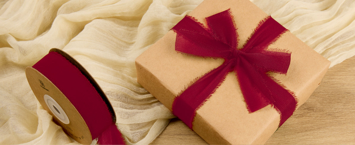 Kraft-wrapped Christmas gifts tied with red, green, and white ribbons on a wooden table