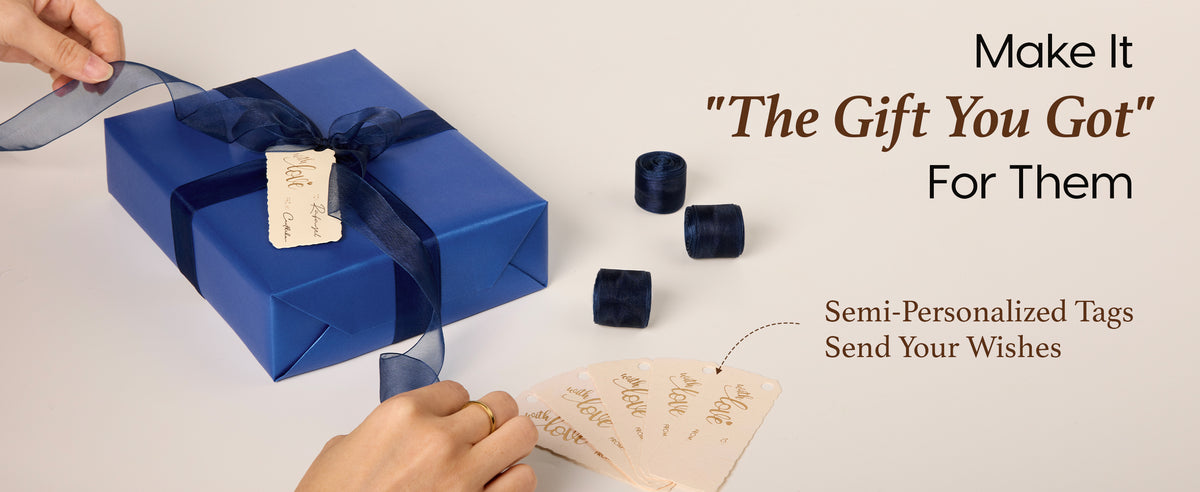 Blue pearly wrapped gift tied with navy organza ribbon and paired with writable cream tags