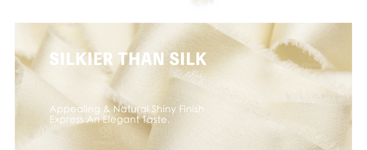 Cream frayed satin ribbon tied into bows on a white gift box and a bouquet of white flowers.