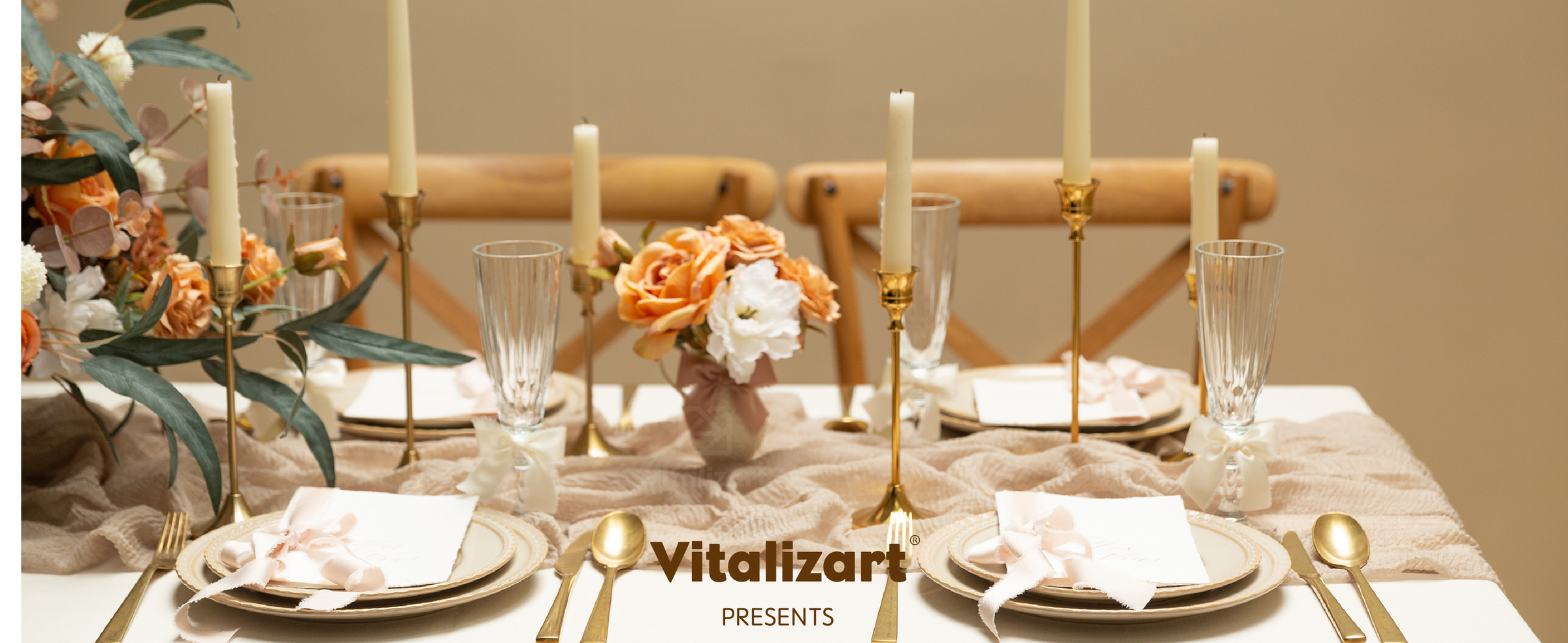 Pale satin ribbon bows decorate glasses and place settings on a formal table with candles and flowers.