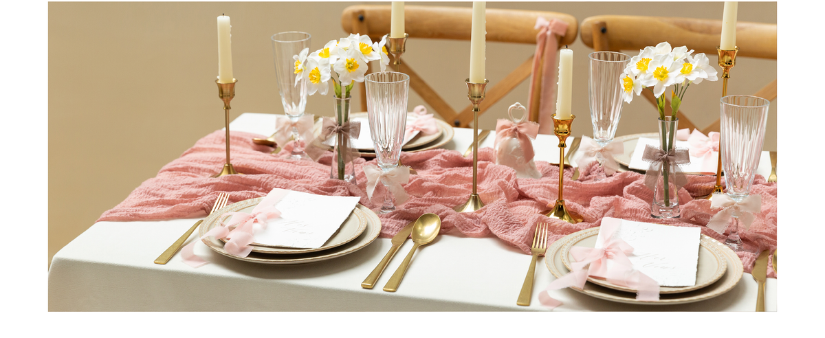 Blush, ivory, and taupe chiffon bows decorate glasses, cards, and flowers on a formal table
